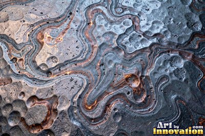 Large shallow hammer marks catching light like ripples on water