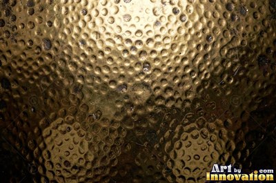 Large shallow hammer marks catching light like ripples on water