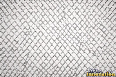 Perforated metal sheet with round holes in a tight grid of blackened iron