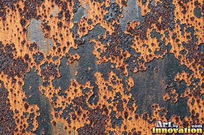 Heavily rusted steel plate with flaking orange scale and dark pits