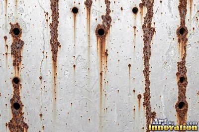 Corroded iron with streaks of rust running down from bolt holes