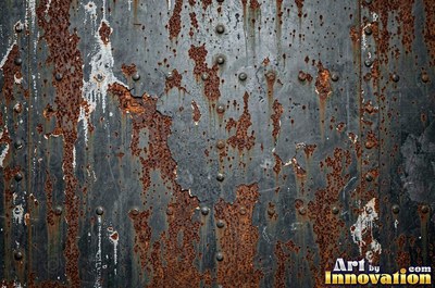 Corroded iron with streaks of rust running down from bolt holes