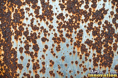 Corroded iron with streaks of rust running down from bolt holes