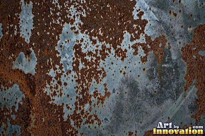 Heavily rusted steel plate with flaking orange scale and dark pits