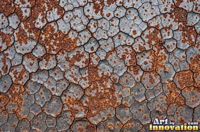 Rust bubbling up under old paint with blisters bursting open