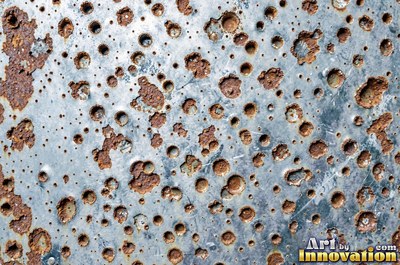 Corroded iron with streaks of rust running down from bolt holes