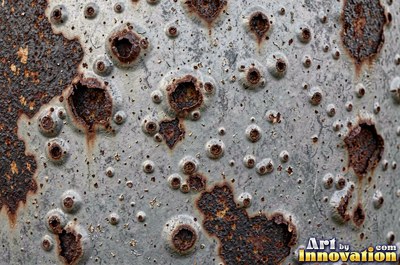 Corroded iron with streaks of rust running down from bolt holes