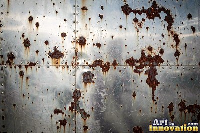 Layered rust surface of orange, brown and black flakes
