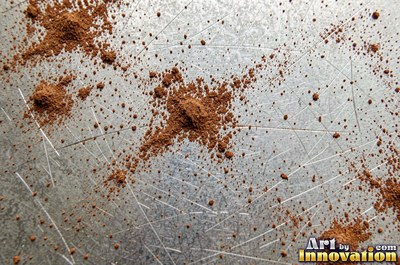 Heavily rusted steel plate with flaking orange scale and dark pits