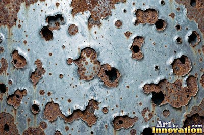 Heavily rusted steel plate with flaking orange scale and dark pits