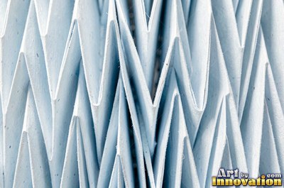 Crumpled foil paper catching bright highlights in pale blue