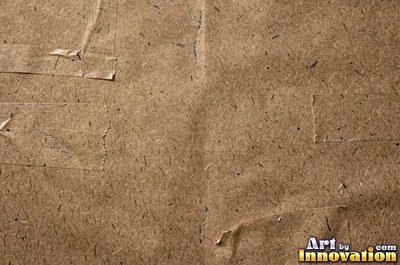 Torn kraft brown cardboard revealing the corrugation underneath