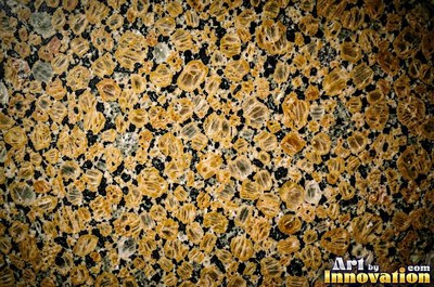 Green gray polished granite with a few large dark crystal clusters