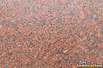 Polished granite with dense speckles of mineral crystals in warm beige