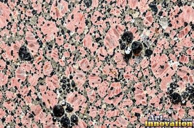 Green gray polished granite with a few large dark crystal clusters
