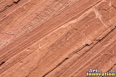 Honeycomb weathering pitted into a rust red sandstone face