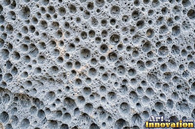 Honeycomb weathering pitted into a rust red sandstone face