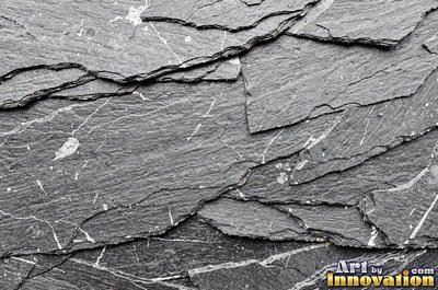 Cleft slate surface with natural ripples and ridges in near black