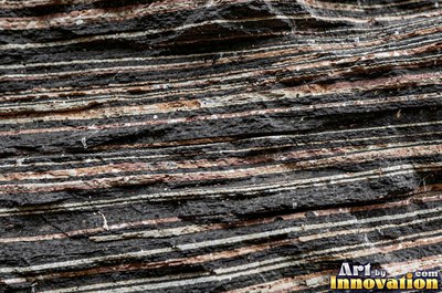 Cleft slate surface with natural ripples and ridges in near black