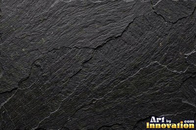 Cleft slate surface with natural ripples and ridges in near black