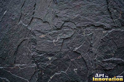 Dry stacked stone wall of flat blue gray slate pieces