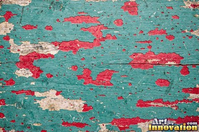 Peeling emerald paint curling off a wooden door in long flakes