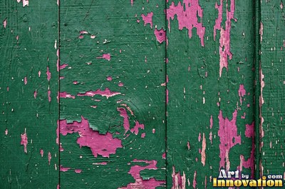 Peeling emerald paint curling off a wooden door in long flakes