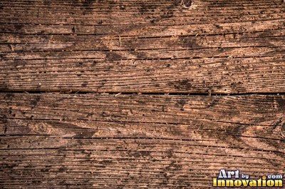 Old barn siding with peeling layers, splits and worn knots