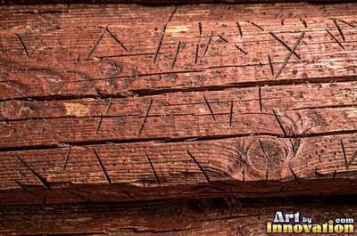 Old barn siding with peeling layers, splits and worn knots