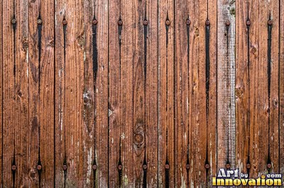 Old barn siding with peeling layers, splits and worn knots