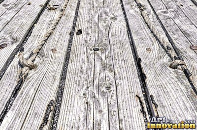 Old barn siding with peeling layers, splits and worn knots