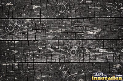 Old barn siding with peeling layers, splits and worn knots