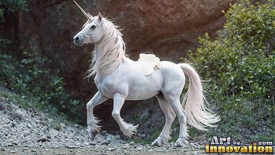 A white unicorn trots along a rocky trail beside green bushes and red rocks