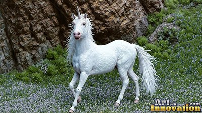 Bright white unicorn standing in purple flowers by a rocky cliff