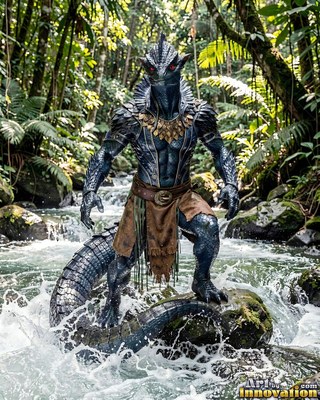 Standing on a rock in a jungle stream, a blue-scaled lizardfolk poses in rushing water