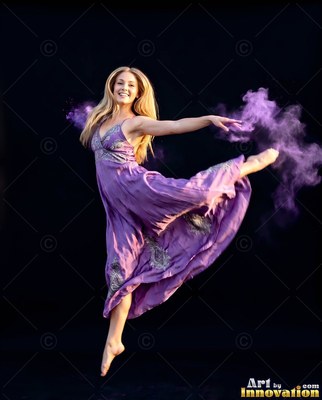 Leaping midair, a blonde woman in a purple dress dances with clouds of purple powder