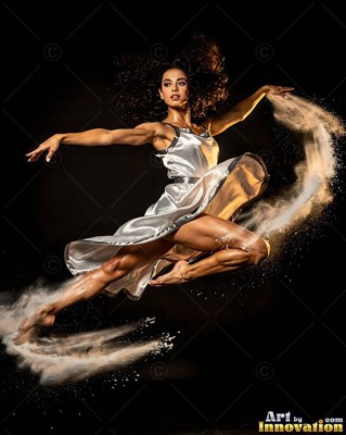 Woman in a silver dress leaps through swirling sand