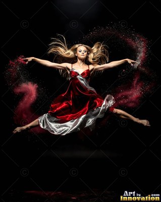 A woman leaps in a split midair, surrounded by arcs of red powder against dark space