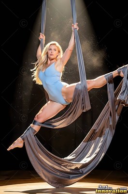 Woman doing a split in gray aerial silks in a spotlight