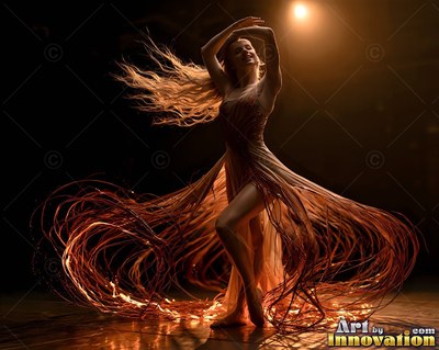 A woman spins in a flowing dress of thin ribbons lit by a warm spotlight