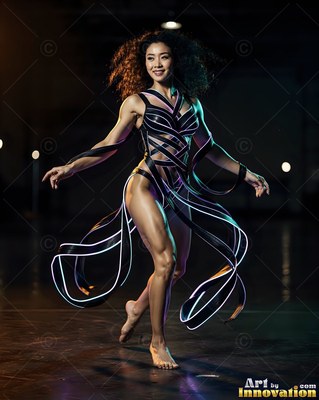 Dancing barefoot in dark space, a smiling woman wears straps edged with bright white neon