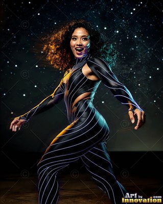 A smiling woman twirls in a striped black suit under pale background lights