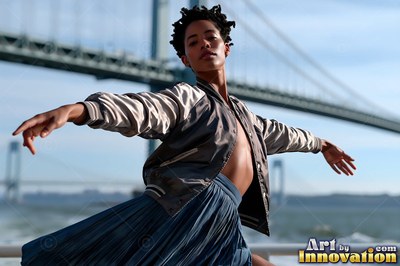 Before a suspension bridge, a woman dances in an unzipped jacket and blue skirt