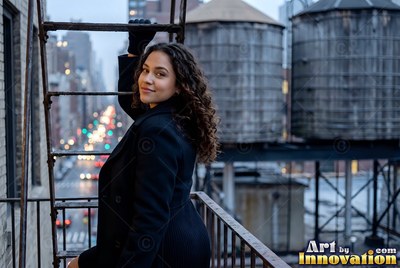 A smiling woman in a black coat climbs a fire escape ladder