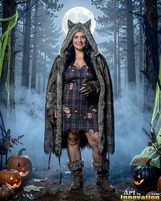 Standing facing forward in a foggy forest, a woman has on a furry wolf costume