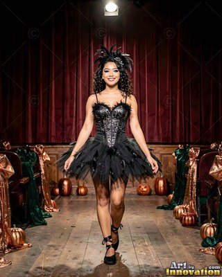 Woman in a black feathered costume on a stage with pumpkins