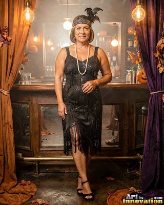 A grinning woman in a black flapper dress stands near a wooden bar in warm light