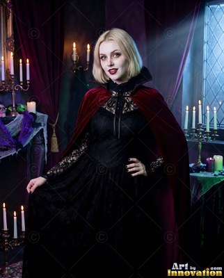 A blonde woman strikes a pose in a black gown and red velvet cape under cool blue window light