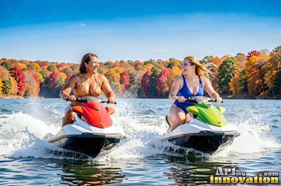 Sitting on jet skis side by side, both women smile on a sunny autumn lake