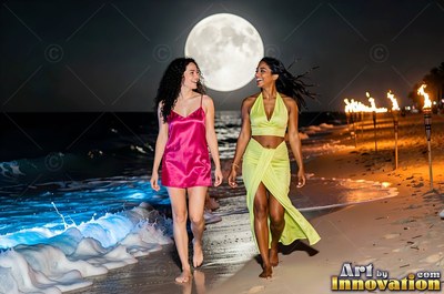 Two women walk along a moonlit beach in satin dresses